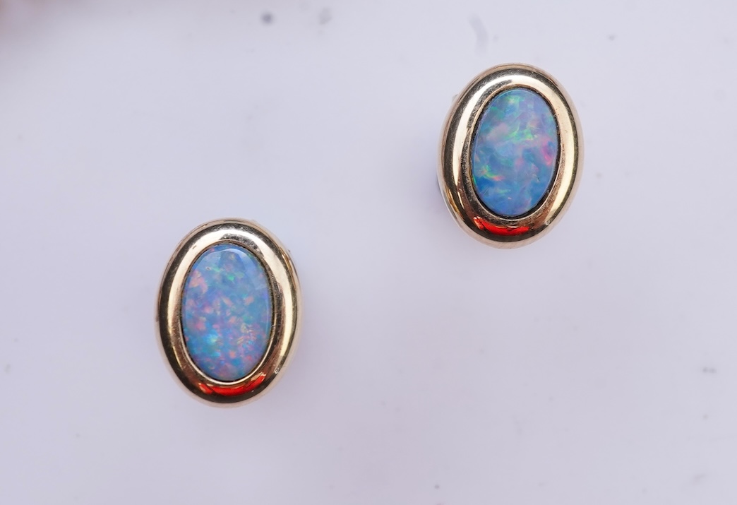 An opal triplet bracelet and pair of earrings, comprising: a gold bracelet set with opal triplets, length 18cm; and a pair of studs set with opal doublets, mounted in gold, length 0.8cm each, post fittings, stamped 585,
